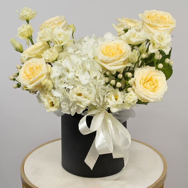 Композиция из Роз Эквадор, Гортензий и Эустом в шляпной коробке «Танец нежности»