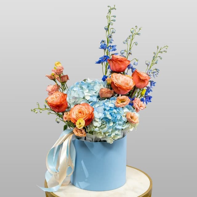 Композиция из Роз Эквадор, Гортензий и Дельфиниума в шляпной коробке «Морская акварель»